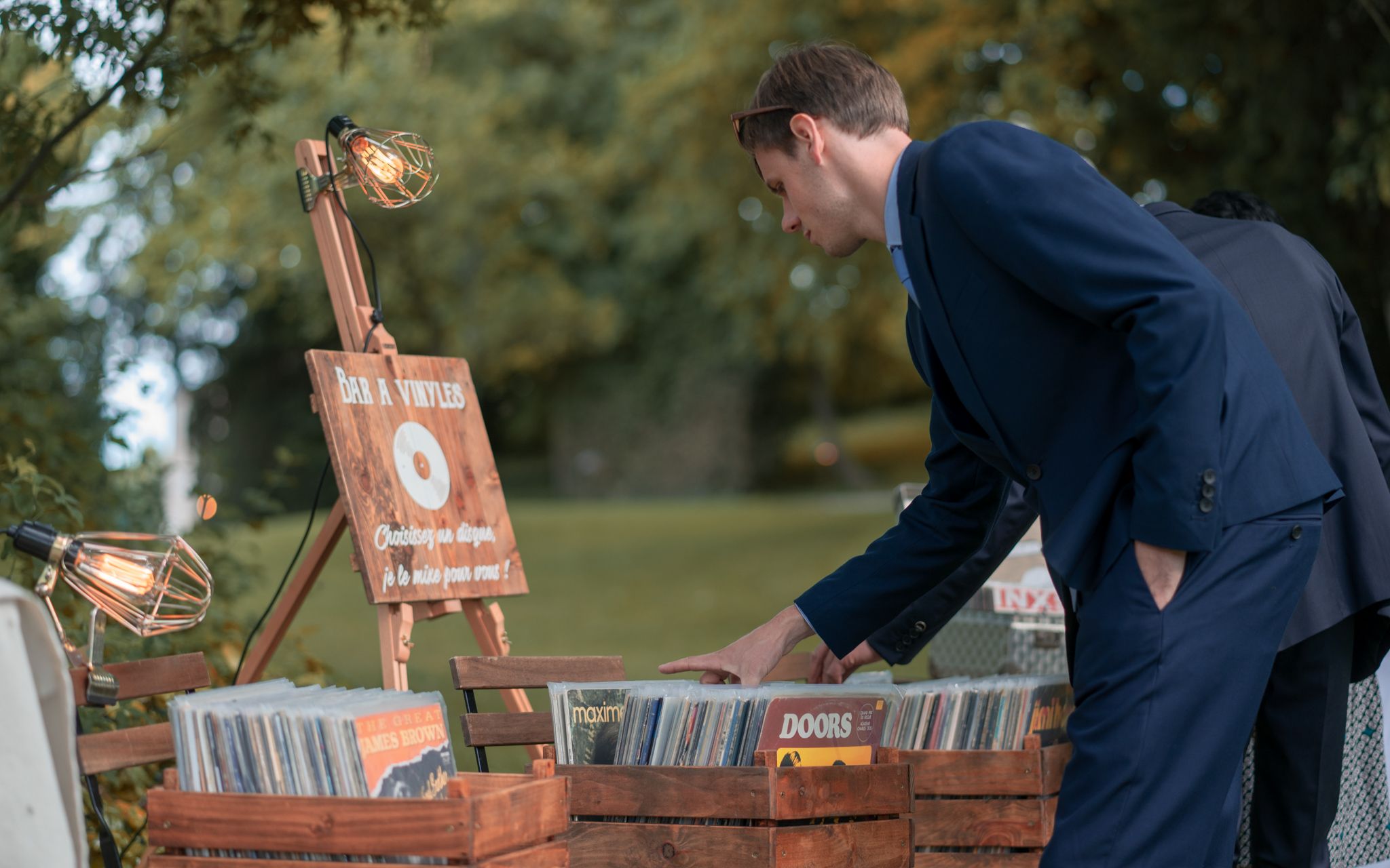 Personne regardant des disques d'un bar à vinyles durant un cocktail de mariage.